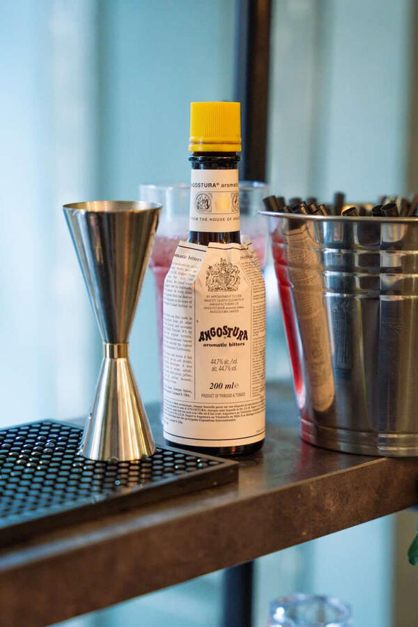 Kwaliteit in elk detail: Echte bitters en professionele tools Detailopname van Angostura Bitters en professionele barmaterialen op de mobiele cocktailbar in Rotterdam. Getuigt van kwaliteit en vakmanschap bij het maken van cocktails op locatie.