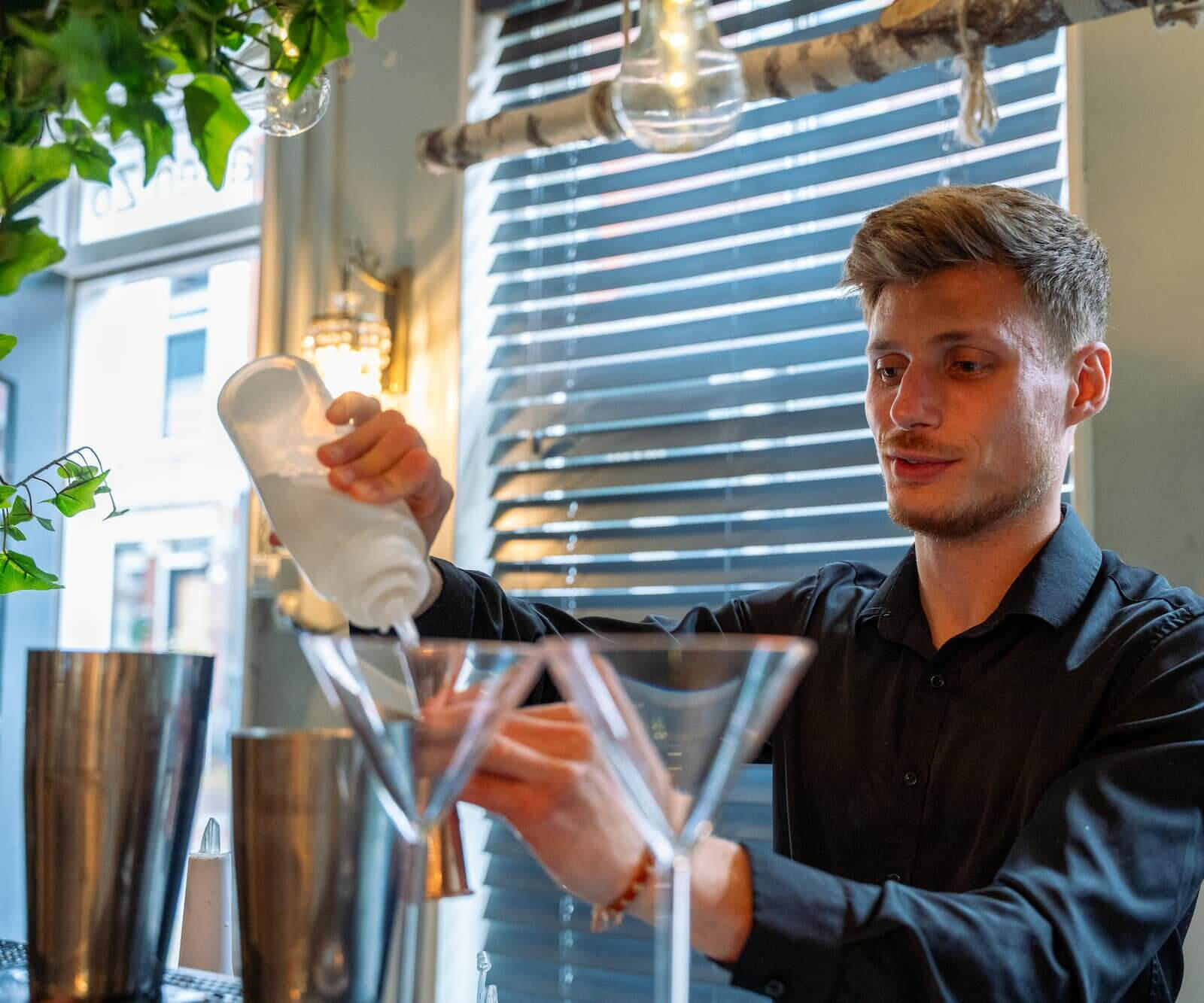 Cocktail workshop op locatie of aan zee Deelnemers leren cocktails shaken tijdens een interactieve workshop van De Cocktail Shaker op het strand van Hoek van Holland.